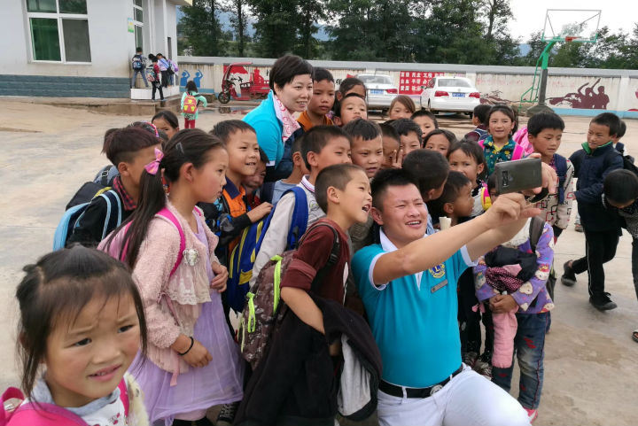 左右手盧建華先生與孩子們一起拍照